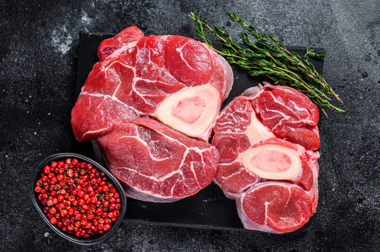 Raw beef shin with peppercorns on a dark surface