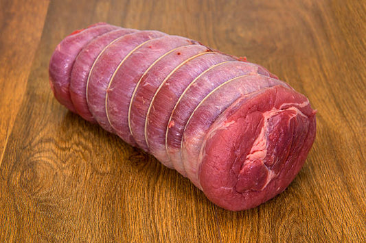 Rolled raw brisket on a wooden surface